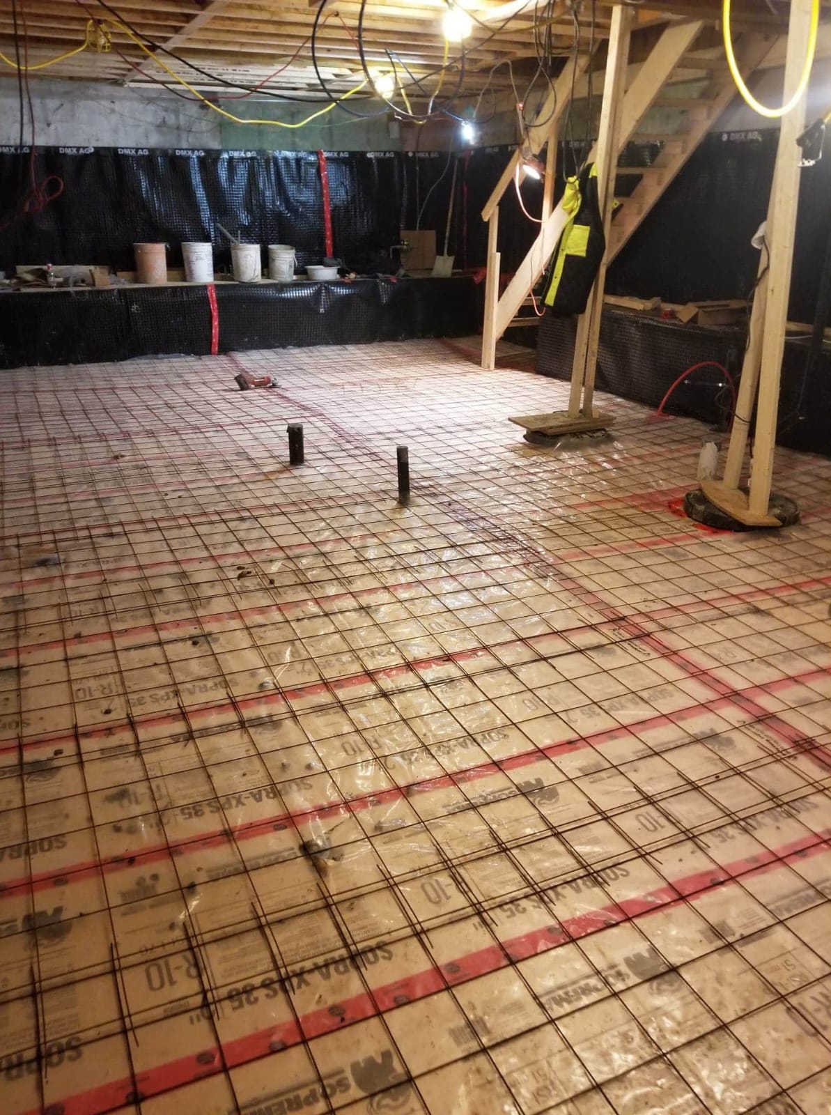 Rebar laid across a lowered basement floor before the pour